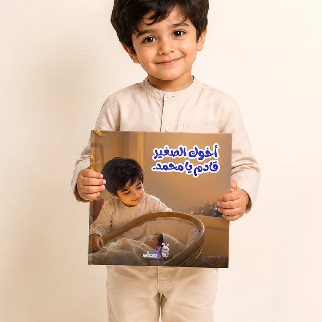 طفل يحمل كتاب «أخوك الصغير قادمٌ يا محمّد»
